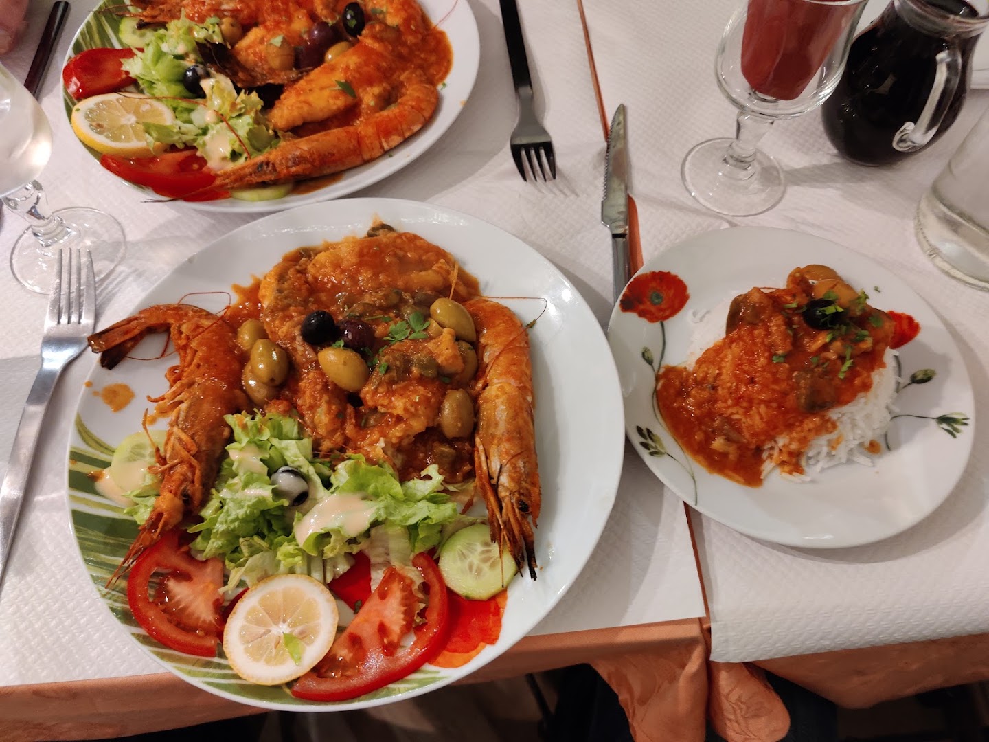Un plat de tomates et fruits de mer au centre d’une table partagée