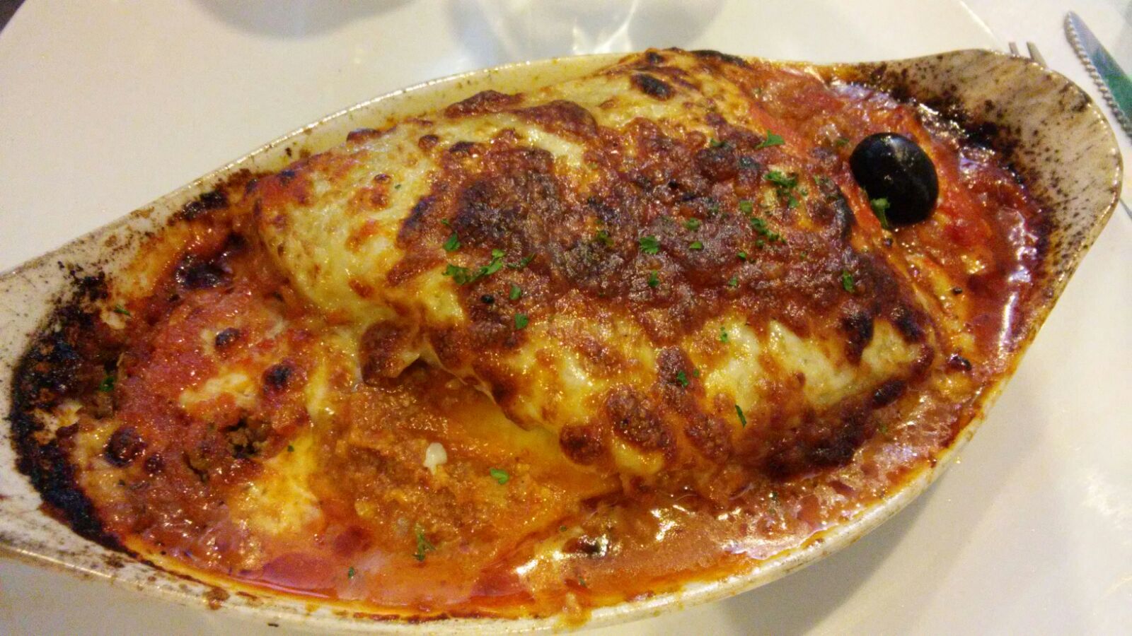 Une portion de lasagne gratinée dans son plat