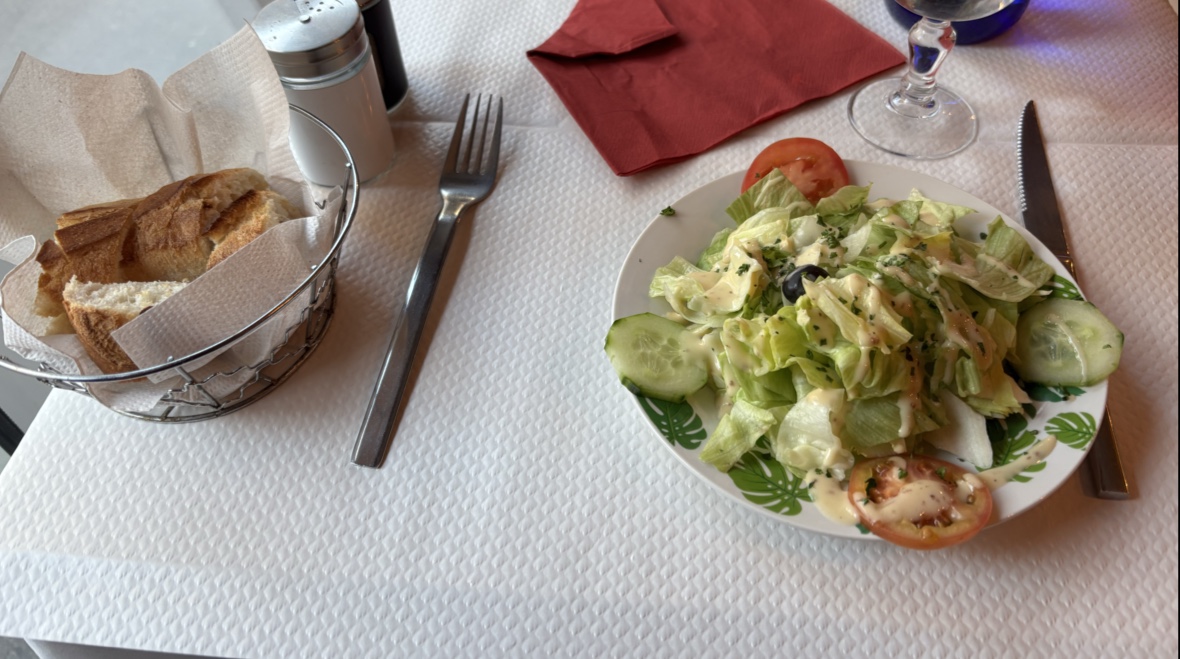 Une salade avec du pain sur une table dressée